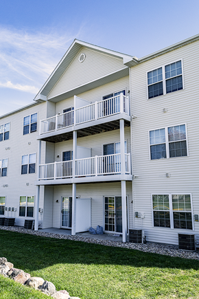 Ames apartment for rent - a white house with a balcony and a grass yard
