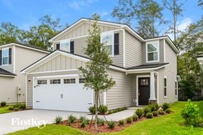Jacksonville house for rent - A modern house with a garage and a tree in front.