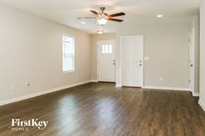 Jacksonville house for rent - A spacious room with wooden floors and a ceiling fan.