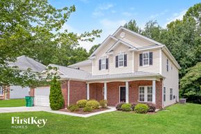 Charlotte house for rent - a home with a brick and white exterior and a green lawn