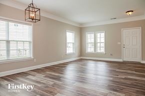 Charlotte house for rent - the living room of an empty house with a white door and windows