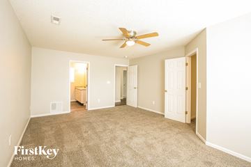 Noblesville house for rent - a spacious living room with carpet and a ceiling fan