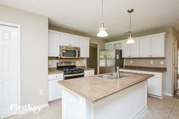 Marietta house for rent - a kitchen with white cabinets and a counter top