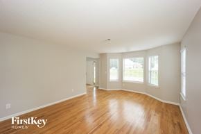 Ellenwood house for rent - an empty living room with wood floors and white walls