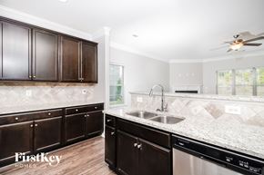Colfax house for rent - a kitchen with wooden cabinets and granite counter tops and a sink