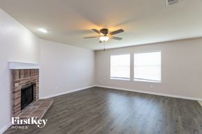 Fort Worth house for rent - a living room with a fireplace and a ceiling fan