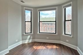 Oak Park apartment for rent - A room with three windows and wooden floors.