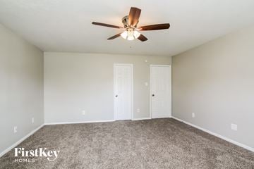 Humble house for rent - the spacious living room with ceiling fan and carpet