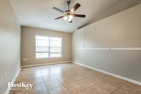 Deltona house for rent - A spacious room with a ceiling fan and tile flooring.
