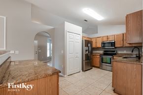 Deltona house for rent - A kitchen with a granite countertop and wooden cabinets.