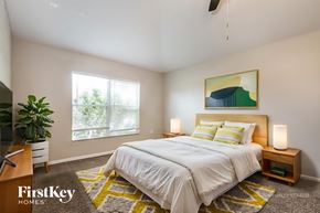 Deltona house for rent - A bedroom with a bed, nightstands, and a painting on the wall.