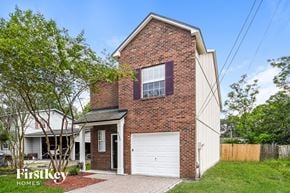 Jacksonville house for rent - the front of a brick house with a white garage door