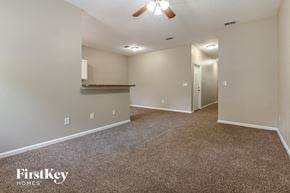 Jacksonville house for rent - a spacious living room with carpeting and a ceiling fan