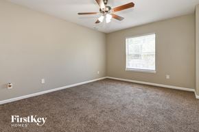 Jacksonville house for rent - a bedroom with carpet and a ceiling fan