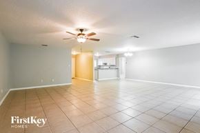 Orlando house for rent - A spacious room with a ceiling fan and tiled flooring.