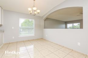 Groveland house for rent - an empty dining room with a large tile floor and a window