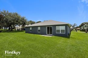 Groveland house for rent - a small gray house in a grassy yard with trees