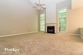 Acworth house for rent - A spacious living room with a fireplace and a ceiling fan.