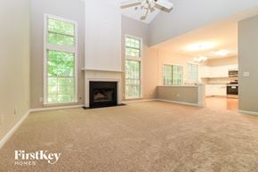 Acworth house for rent - A spacious living room with a fireplace and a ceiling fan.