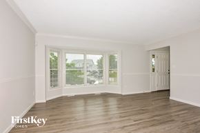 O'fallon house for rent - a living room with white walls and wood floors and large windows