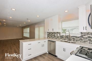 O'fallon house for rent - a white kitchen with stainless steel appliances and white cabinets