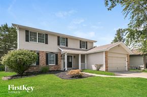 Weldon Springs house for rent - a white and brick house with green grass and trees