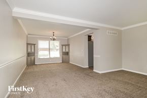 Weldon Springs house for rent - an empty living room with white walls and carpet