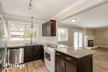 Weldon Springs house for rent - a kitchen with an island and a stove and a sink