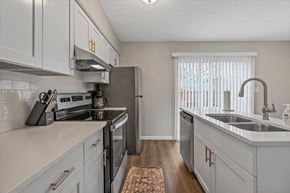 College Park apartment for rent - an open kitchen with white cabinets and stainless steel appliances