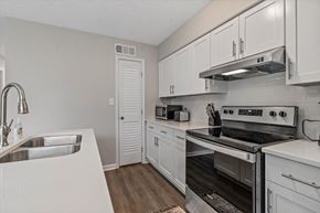 College Park apartment for rent - an empty kitchen with white cabinets and stainless steel appliances