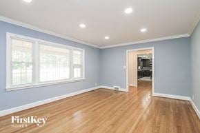 Winston Salem house for rent - the living room of a house with blue walls and a wooden floor
