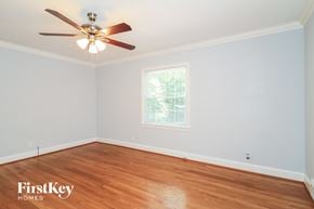 Winston Salem house for rent - a bedroom with wood floors and a ceiling fan