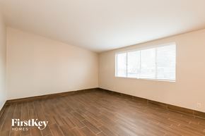Tucson house for rent - A room with wooden flooring and a window with blinds.