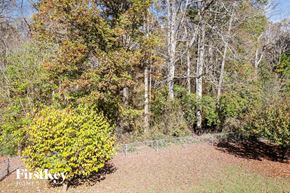 Linwood house for rent - a chain link fence surrounds a yard with trees