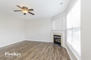 Charlotte house for rent - a living room with a fireplace and a ceiling fan