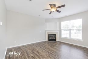 Charlotte house for rent - a living room with a fireplace and a ceiling fan