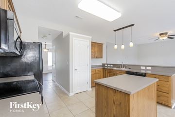 Charlotte house for rent - a kitchen with a white counter top and a black refrigerator