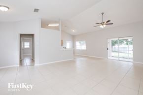 Clermont house for rent - an empty living room with white tile floors and a ceiling fan