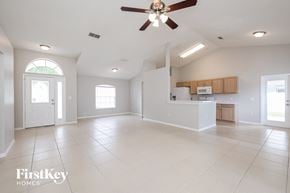 Clermont house for rent - an empty living room and kitchen with a ceiling fan