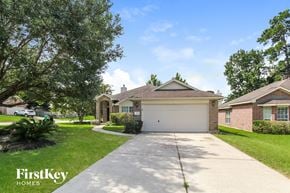 Conroe house for rent - a house with a driveway and a garage door