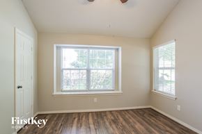 Conroe house for rent - the living room of a home with a large window and wooden floors