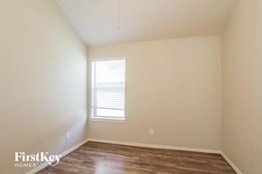 Conroe house for rent - a bedroom with wood floors and white walls and a window