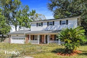 Jacksonville house for rent - A house with a white garage door and a brick chimney is for sale.