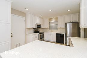 Jacksonville house for rent - A kitchen with white cabinets and appliances.
