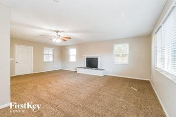 Jacksonville house for rent - A spacious living room with a television and a ceiling fan.