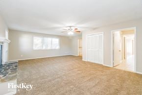 Jacksonville house for rent - A spacious room with a carpeted floor and a ceiling fan.