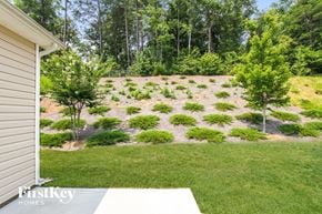 Mooresville house for rent - A backyard with a grassy area and a tree.
