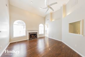 Helena house for rent - A spacious room with a fireplace and a ceiling fan.