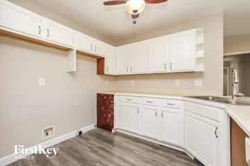 Clarksville house for rent - A kitchen with white cabinets and a wooden floor.