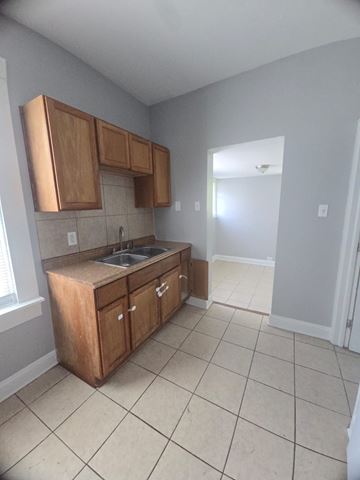 Cincinnati house for rent - A kitchen with wooden cabinets and a sink.